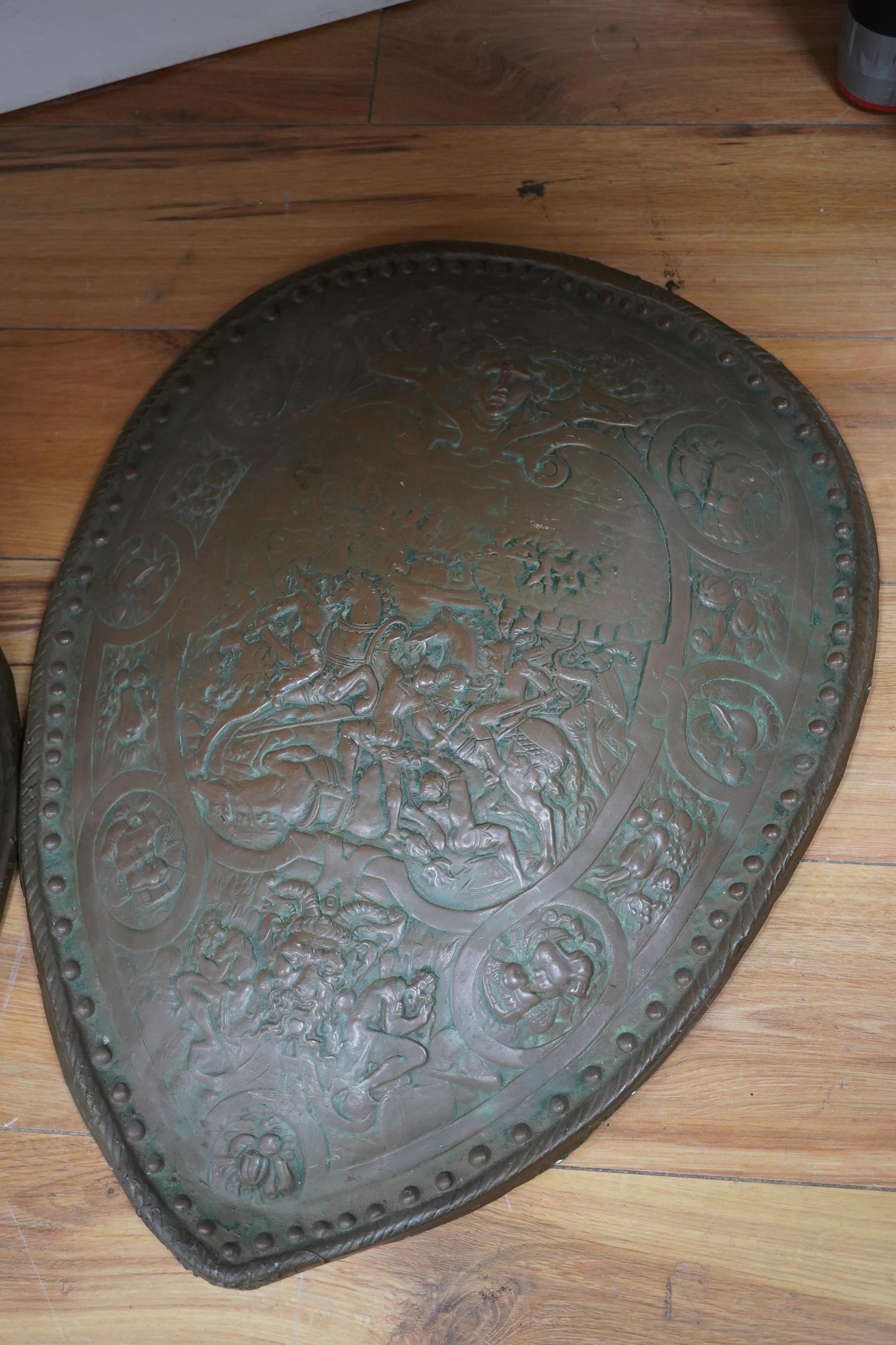 Three metal castings of decorative embossed shields, decorated with battle scenes, ancient armour, etc., diameter of largest 51.5cm. Condition - fair